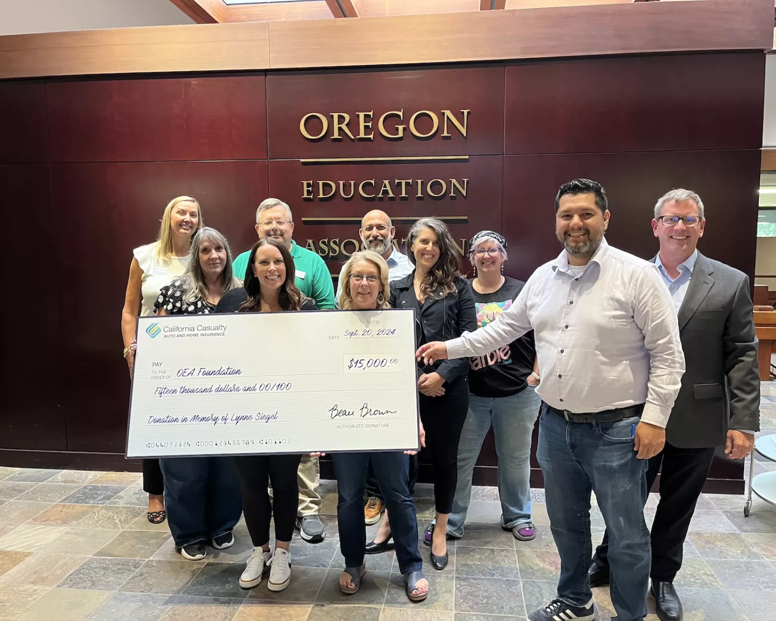 OEA members stand behind a large check for $15,000 for the OEA Foundation from California Casualty