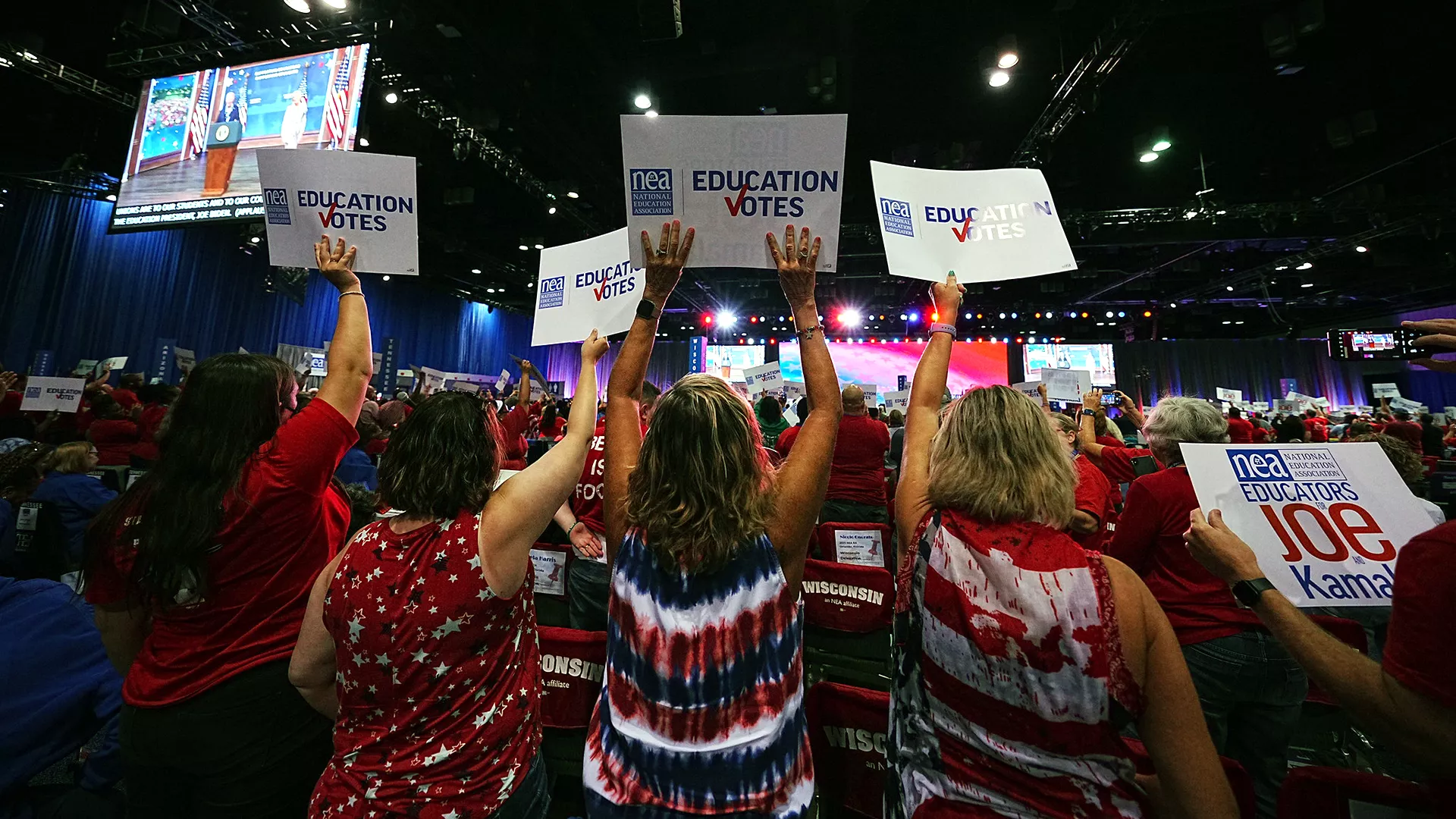Delegates to the 2023 NEA RA hold up signs saying Education Votes