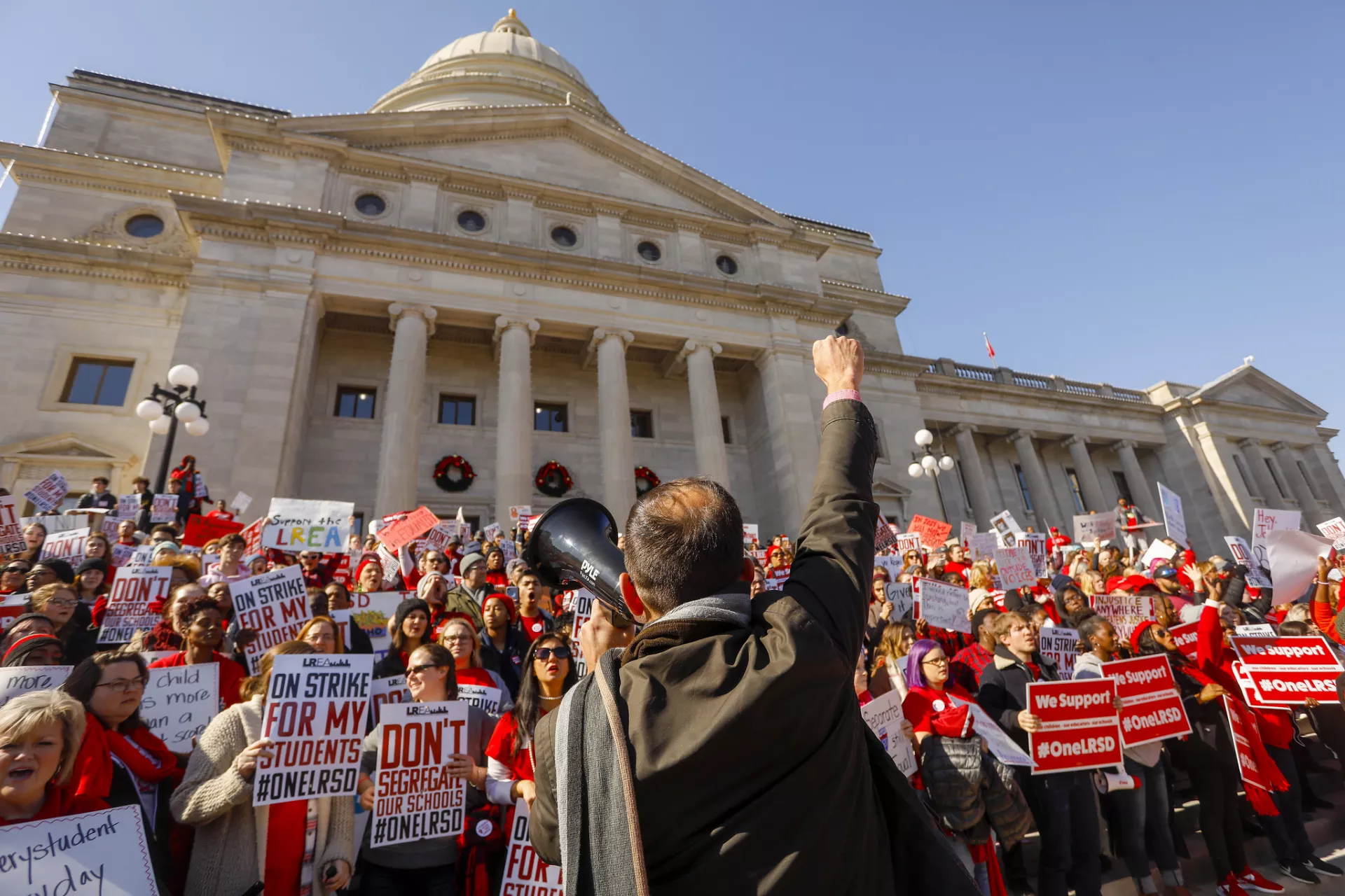 Man w/fist raised in front of a protest at the Arkansas capitol