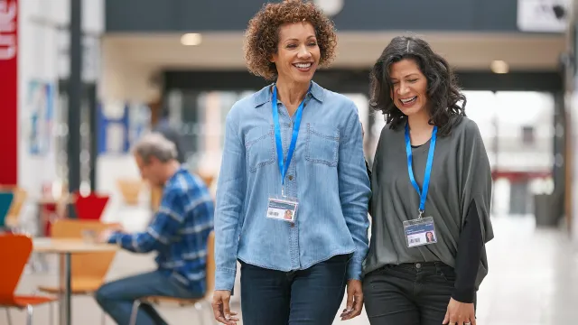 Two women educators walking through a school cafeteria