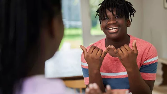 Two Black students smiling at each other