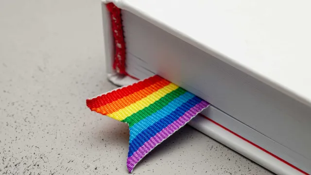 A book is marked with a pride ribbon