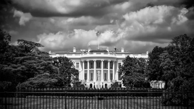 black and white photo of the white house with cloudy skies